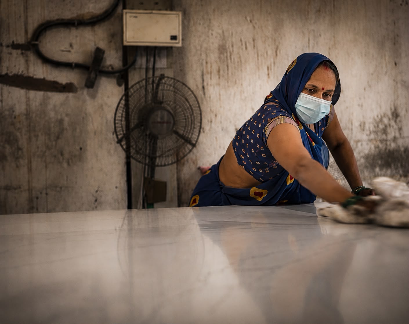 A SUNEX worker hand-finishing an engineered quartz slab at the Jaipur factory