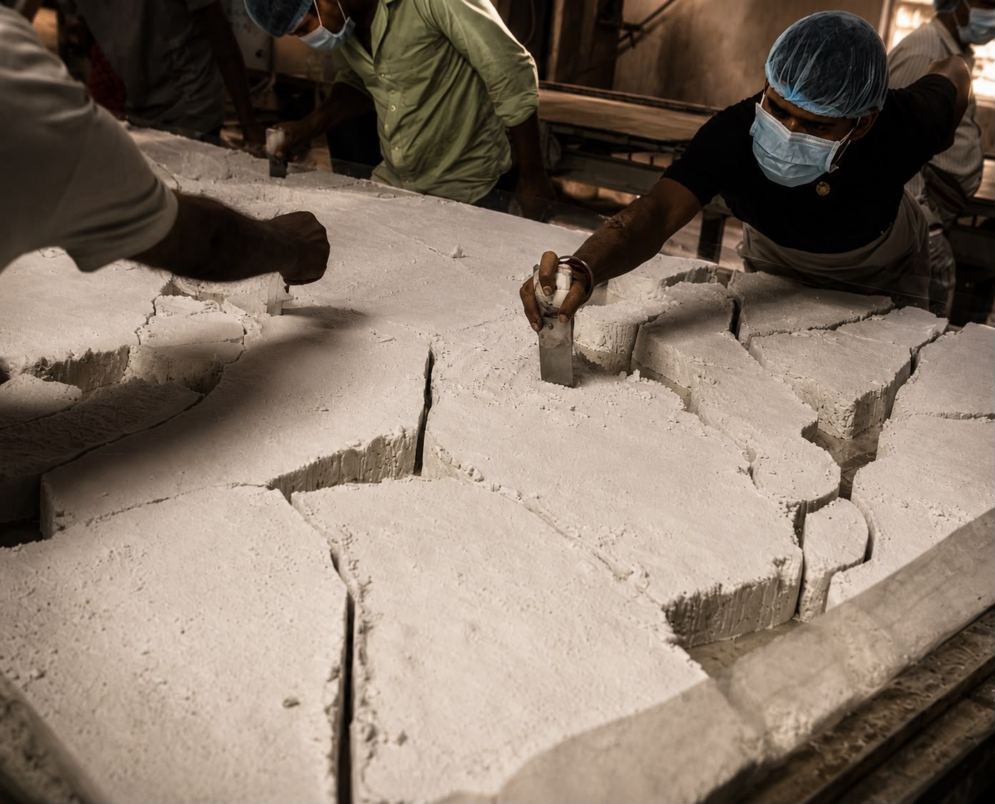 SUNEX workers spreading the engineered quartz mix on the forming table in Jaipur