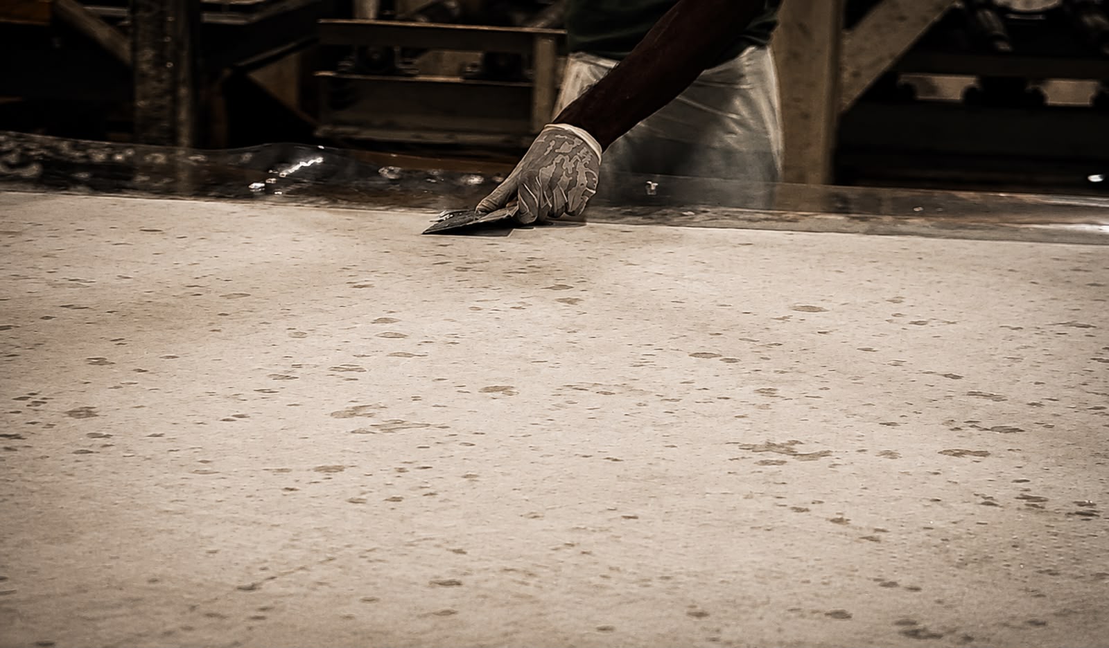 A SUNEX worker leveling the surface of a pressed engineered quartz slab