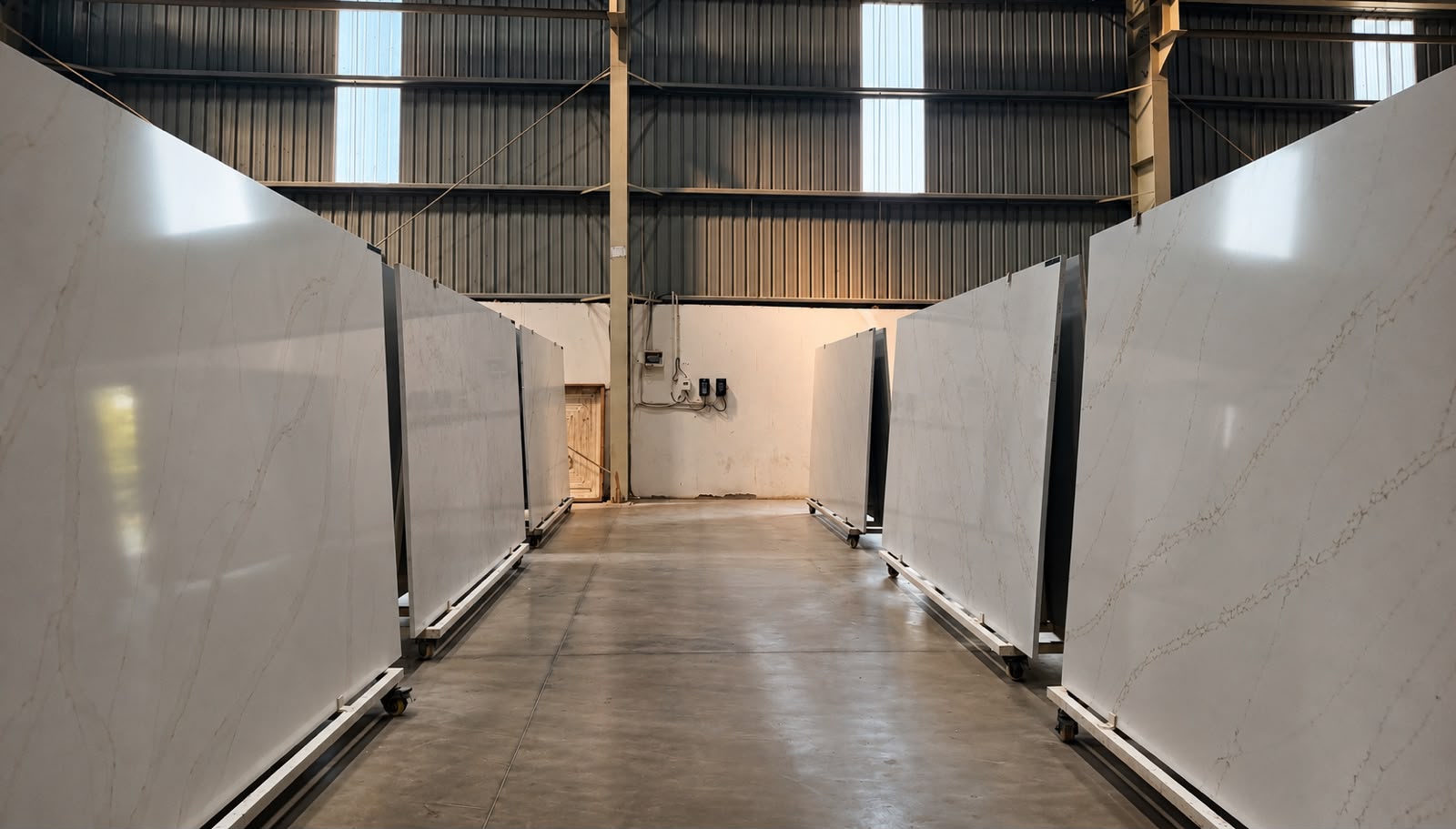 Finished SUNEX engineered quartz slabs on racks inside the Jaipur factory